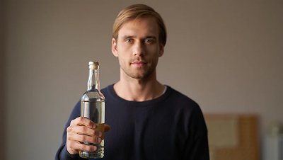 Мужчина держит бутылку алкоголя