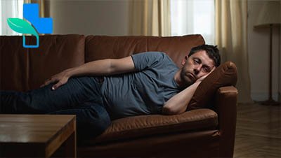 Мужчина без сил лежит на диване